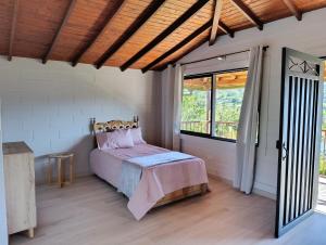 Un dormitorio con una cama y una ventana grande en Alma Guatapé, en Guatapé 24 fotos más