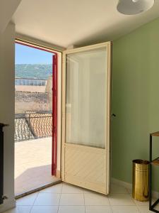 an open door with a view of a balcony at Casetta in piazza in Palazzo Adriano