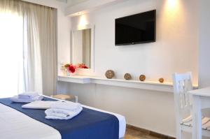 a hotel room with a bed and a television on the wall at Hotel Korali in Troulos