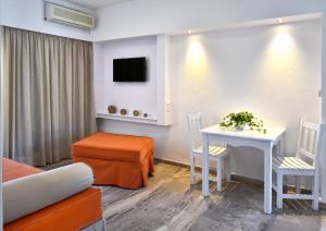 a living room with a table and chairs and a tv at Hotel Korali in Troulos