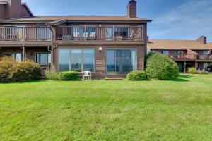 a large house with a lawn in front of it at Pool Access Waterfront Lake Memphremagog Condo! in Newport