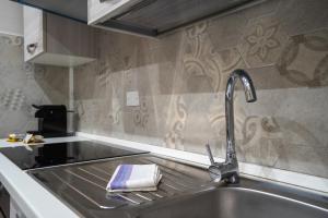 a kitchen sink with a faucet next to a stove at Metro18Dic - Stazione Porta Susa - Grazioso Bilocale in Turin +11 photos