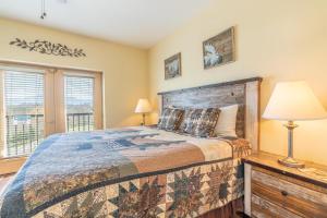 a bedroom with a bed and a lamp and windows at Mountain View Condo 3702 in Pigeon Forge