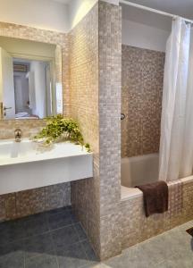 a bathroom with a sink and a bath tub at Hotel Korali in Troulos