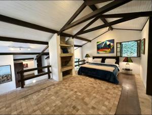 a large bedroom with a bed and a wooden ceiling at Chalé em Mata Atlântica no Coração de Petrópolis in Petrópolis