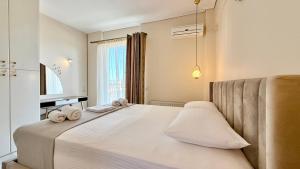 a bedroom with a large white bed with towels on it at Free Spirit Sophie in Kalamata