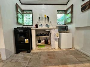 a kitchen with a stove and a refrigerator at Chalé em Mata Atlântica no Coração de Petrópolis in Petrópolis +10 photos