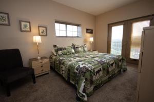 a bedroom with a bed and a chair and windows at Mountain View Condo 1501 in Pigeon Forge +36 photos