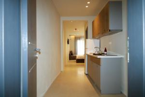 a kitchen with a white refrigerator and a hallway at ELAIA Αpartments in Alexandroupoli