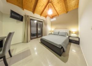 a bedroom with a bed and a desk and a window at Eden Villas in Anafonítria