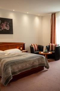 a hotel room with a bed and two chairs at Das kleine Landhotel im Fichtelgebirge in Fichtelberg
