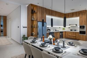a kitchen with a table with chairs and a refrigerator at Yasmin Homes - Luxury Apartments in Medina