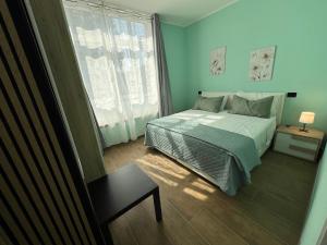 a blue bedroom with a bed and a window at Rubiera Sunny Apartments in Rubiera