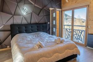 a bedroom with a large bed with a large window at Résidence Pramouton - Chalet Le loup d'Orres MAE-3303 in Les Orres