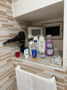 a bathroom counter with a bunch of bottles of detergents at La Maison di Annamaria in Bari +6 photos