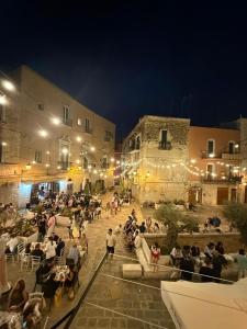a crowd of people sitting in a courtyard at night at La Maison di Annamaria in Bari