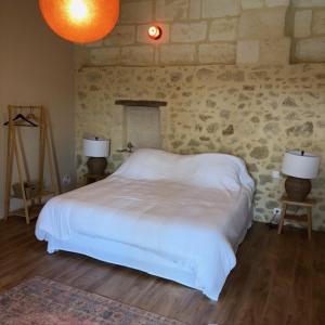 a bedroom with a white bed and two lamps at Château Clos des Maurins in Vérac