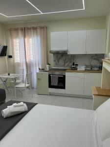 a kitchen with white cabinets and a table with chairs at Perla Marina B&B in Nicotera Marina +39 photos