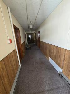 an empty hallway in an office building with wooden walls at Coal Branch Hotel & Restaurant in Coalspur