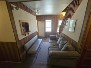 a living room with a couch and a staircase at Coal Branch Hotel & Restaurant in Coalspur +1 photo