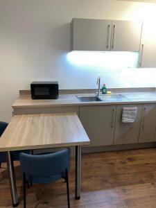 a kitchen with a sink and a wooden table at Unique Homes in Barking