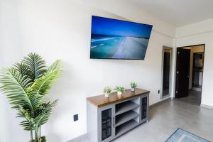 Una sala de estar con un televisor de pantalla plana en una pared. en Vista Pedregal-Stylish Holiday Apartment in the Heart of Cabo, 2 Minutes walk to Marina, en Cabo San Lucas