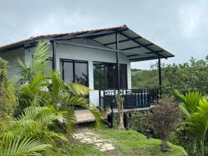 a small house in the middle of a field at Cabaña Lago de Sol in El Castillo de La Fortuna