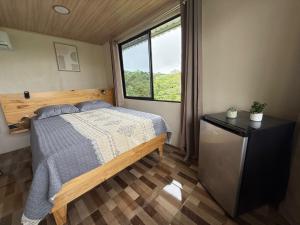 a bedroom with a bed and a window at Cabaña Lago de Sol in El Castillo de La Fortuna