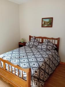 a bedroom with a bed with a black and white comforter at La maison du Vigneron in Veuzain-sur-Loire