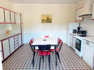 a kitchen with a table and red chairs in it at La maison du Vigneron in Veuzain-sur-Loire