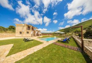 a backyard with a pool and a house at Eden Villas in Anafonítria