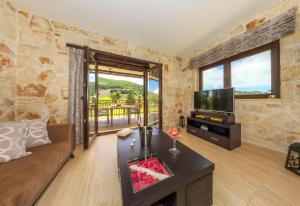 a living room with a couch and a television at Eden Villas in Anafonítria