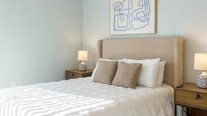 Un dormitorio con una cama blanca con dos mesitas de noche. en Canal Walk District Apartments by Landing, en Indianápolis