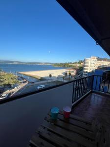 a balcony with a view of a beach and the ocean at Playa centro Sada 4 dormitorios in Sada