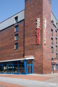 a red brick building with a hotel sign on it at IntercityHotel Hamburg Altona in Hamburg
