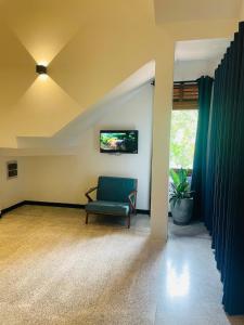 salon z zielonym krzesłem i telewizorem w obiekcie Calathea inn unawatuna w mieście Galle