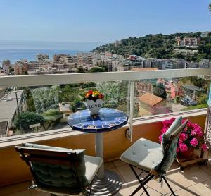 a balcony with a table with a vase on it at Appartement spacieux, vue imprenable in Roquebrune-Cap-Martin