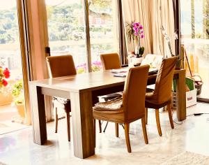 a dining room table and chairs in a room with a window at Appartement spacieux, vue imprenable in Roquebrune-Cap-Martin