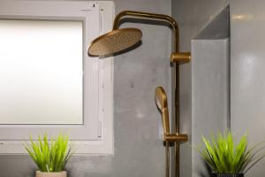 a shower head in a bathroom next to a window at ELAIA Αpartments in Alexandroupoli