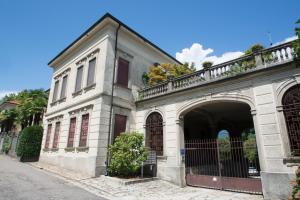 un edificio blanco con una puerta y un arco en La Casa di Porto, en Porto Valtravaglia