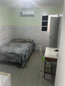 a bedroom with a bed and a table and a table and chair at Elite Hotel 02 in Teresina