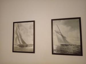 two framed photographs of two sailboats on a wall at VELE with parking and sea view in Makarska +1 photo