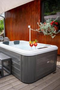 a jacuzzi tub on a deck with two drinks at Das kleine Landhotel im Fichtelgebirge in Fichtelberg +94 photos