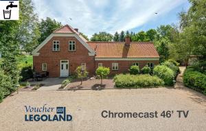 a red brick house with a driveway in front of it at Awesome Foersum in Tarm