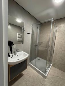 a bathroom with a glass shower and a sink at Hotel Hostel Перехрестя in Chistilov
