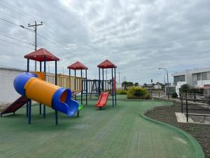 a playground with a slide on a park at Casa moderna en Urb privada Seguridad 24h manta jaramijo in Manta