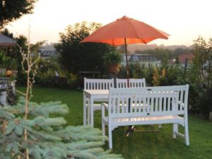 two white benches and an umbrella in a yard at 2 Norit Schlosser Comfortable holiday residence in Heidenau +12 photos