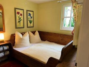 a bedroom with a bed with pillows and a window at Landhaus Weickenhof Comfortable holiday residence in Oberweickenhof +29 photos