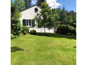 a small white house with a tree in a yard at Landhaus Weickenhof Comfortable holiday residence in Oberweickenhof