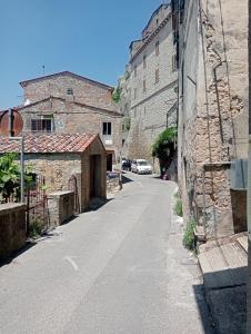 an empty street in a town with stone buildings at Casa Giovy in Roccastrada